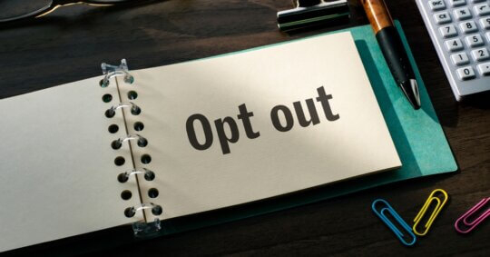 opt out on piece of paper on desk with office supplies and stationary