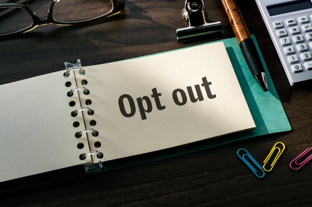 opt out on piece of paper on desk with office supplies and stationary