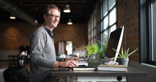 man on laptop at desk performing spydialer opt out