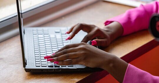 woman with pink nails on laptop performing FastBackgroundCheck opt out