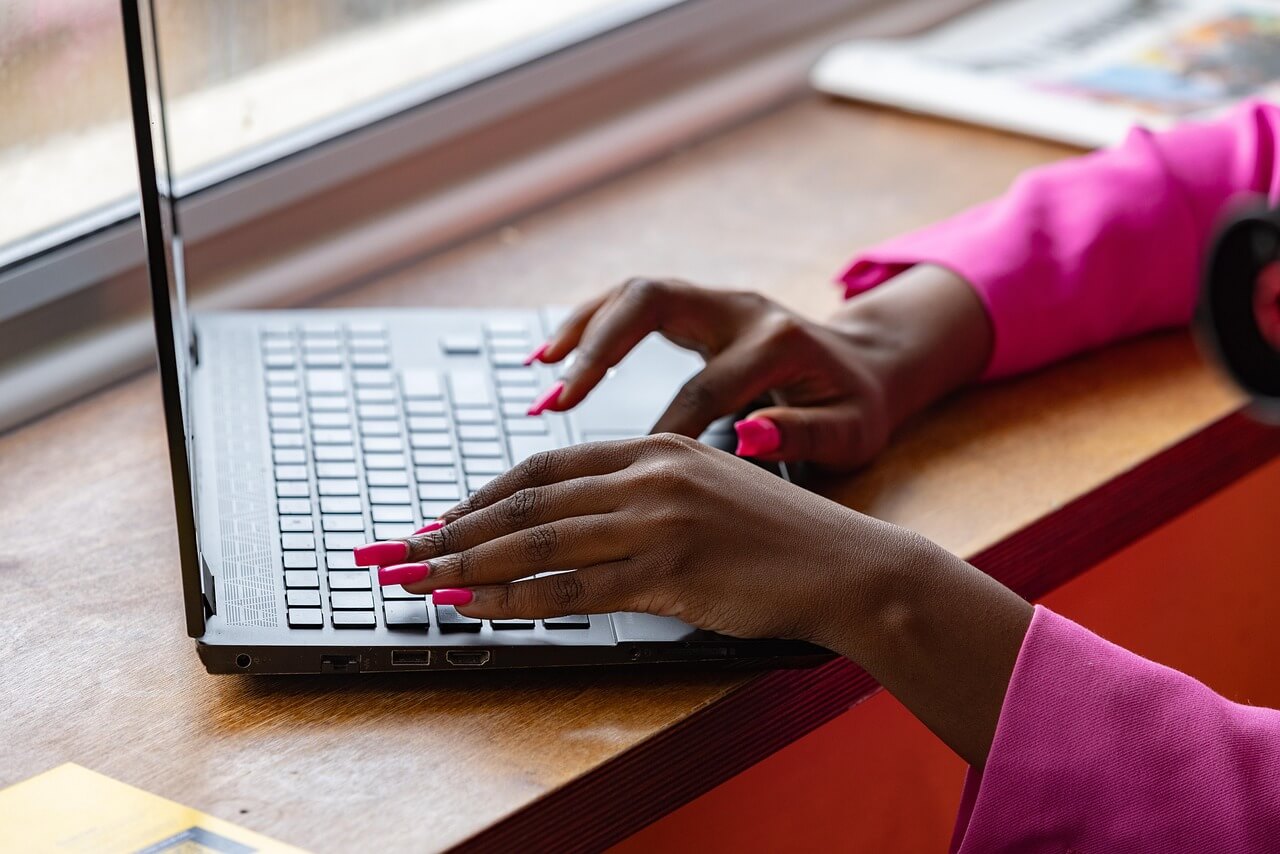 woman with pink nails on laptop performing FastBackgroundCheck opt out