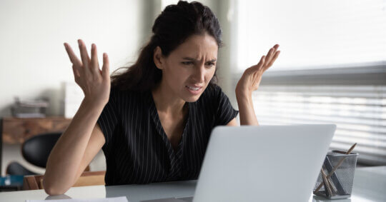 A woman anxiously looking at her computer and searching for a Nuwber opt-out forms.