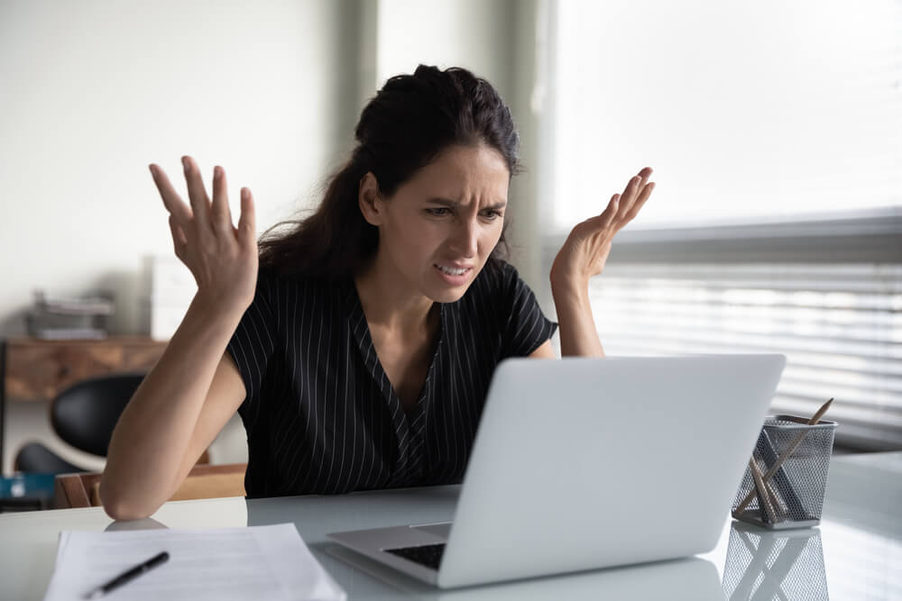 A woman anxiously looking at her computer and searching for a Nuwber opt-out forms.