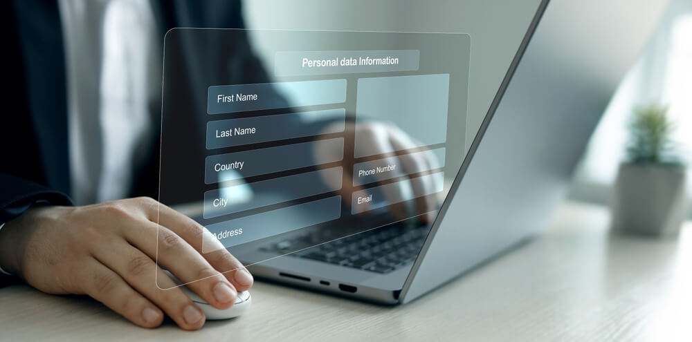 Person using a laptop with a digital overlay showing a personal data information form, symbolizing online privacy and USPhoneBook opt out.
