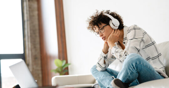 A woman wearing headphones and learning how to complete the US Search opt out process.