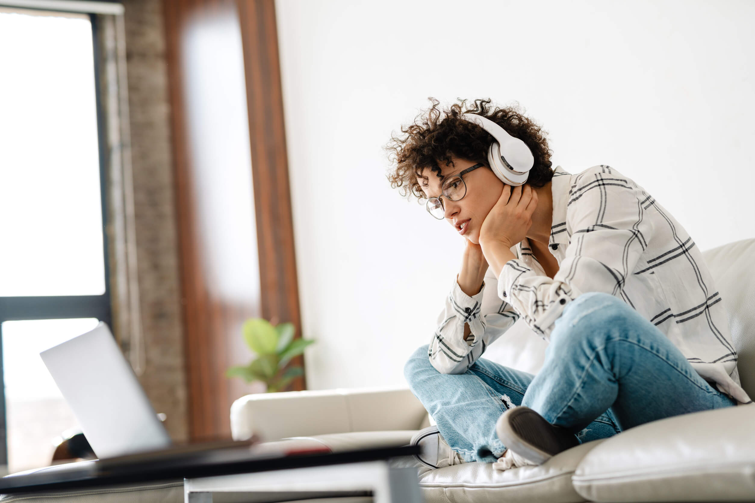 A woman wearing headphones and learning how to complete the US Search opt out process.