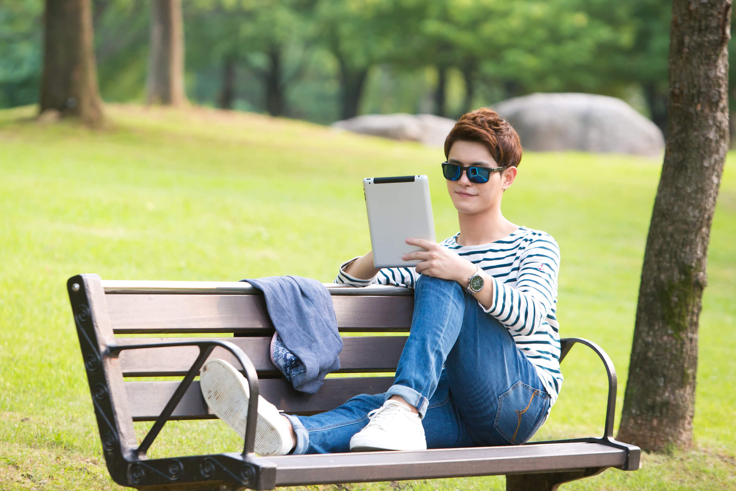 A young man using a computer on a park bench after learning about the IDTrue opt out process.