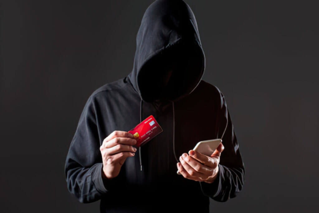 A scammer trying to steal someone's data with a credit card in their hand.